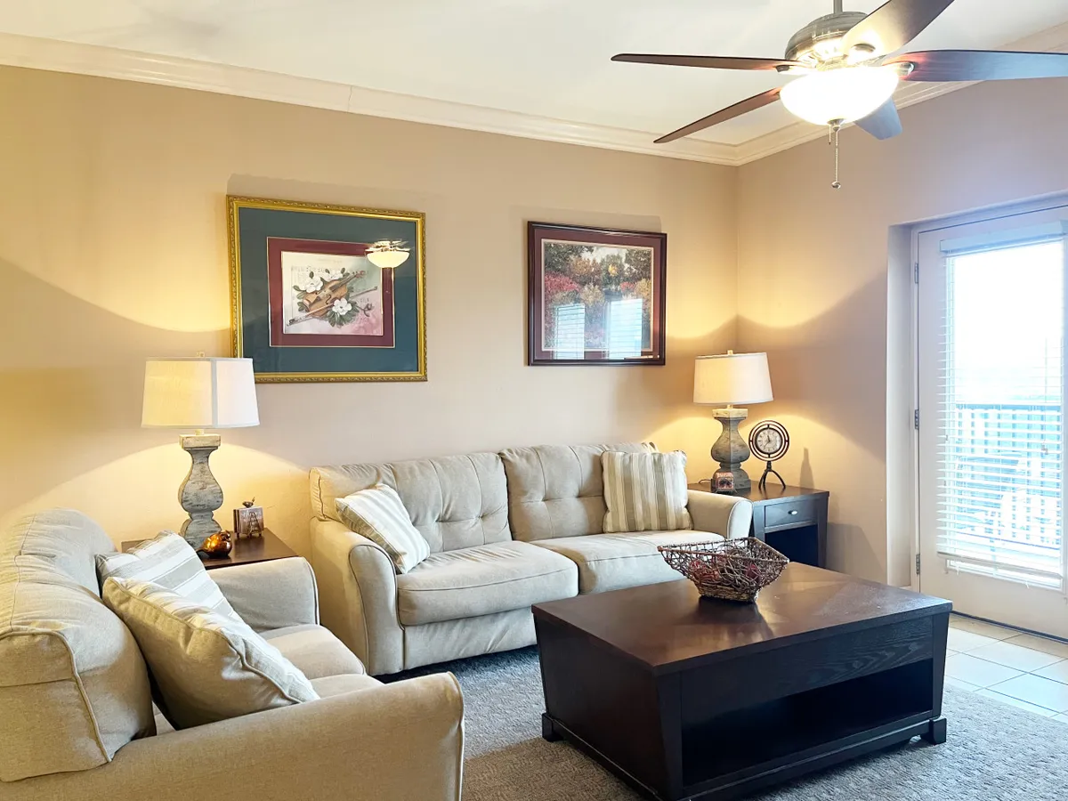 A comfortable and welcoming entry area is visible, featuring a sofa set, coffee table, and artwork on the walls. Table lamps add a soft glow, and the layout suggests an inviting space where guests would first arrive and settle in. The open design and tasteful decor reinforce an immediate sense of relaxation upon entry.